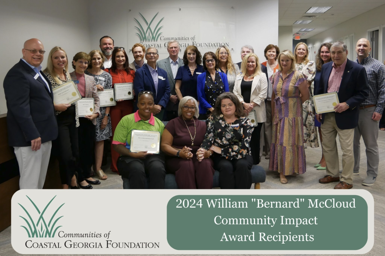 Group of award recipients smiling, holding certificates indoors.