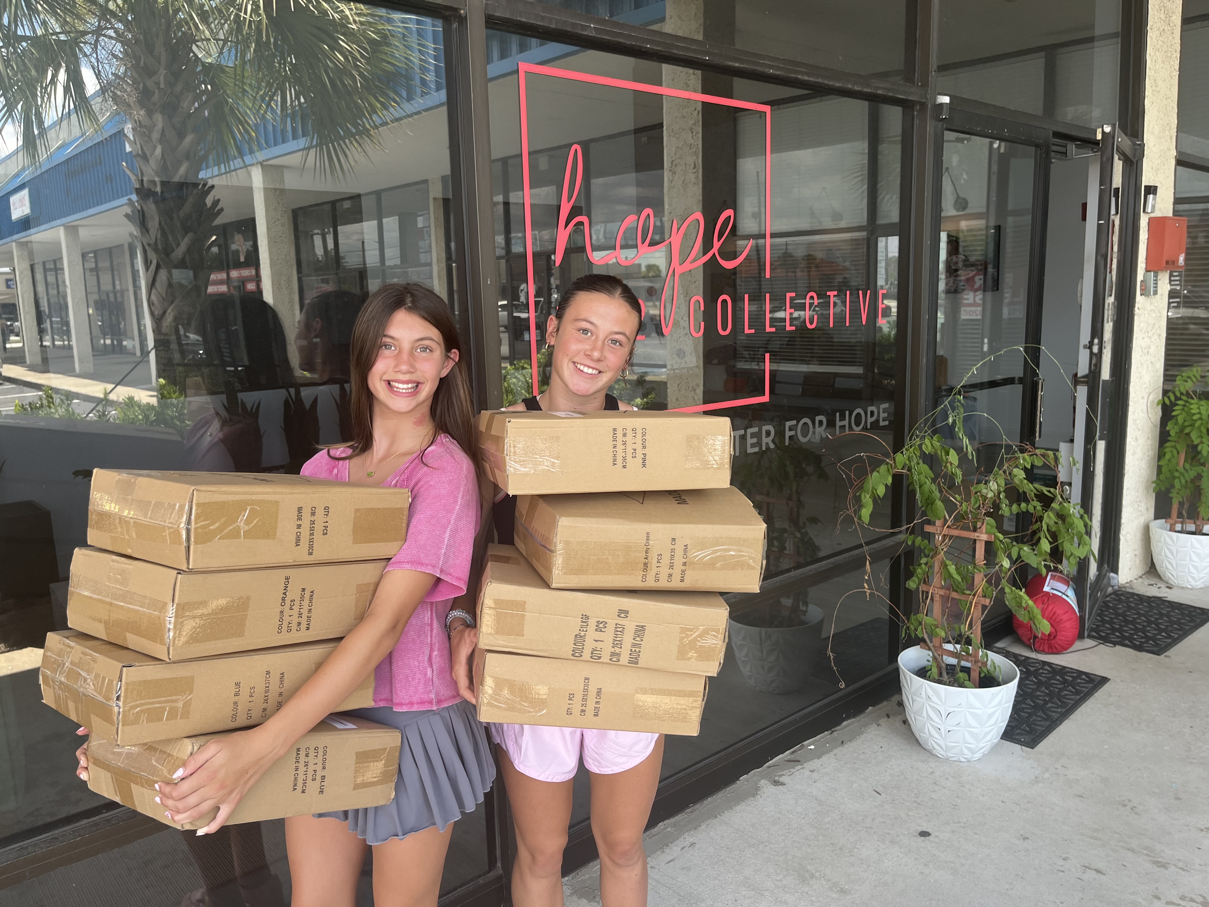 2 girls carrying boxes
